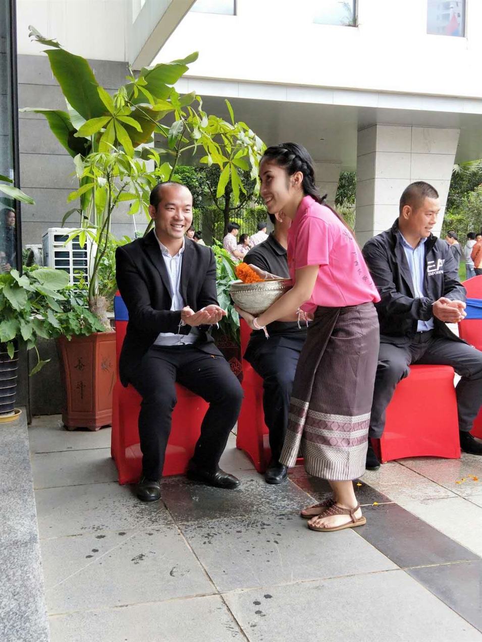 老撾駐廣西留學(xué)生代表將浸有花瓣的香水灑客人的手上，表示對嘉賓的美好祝福（圖一）